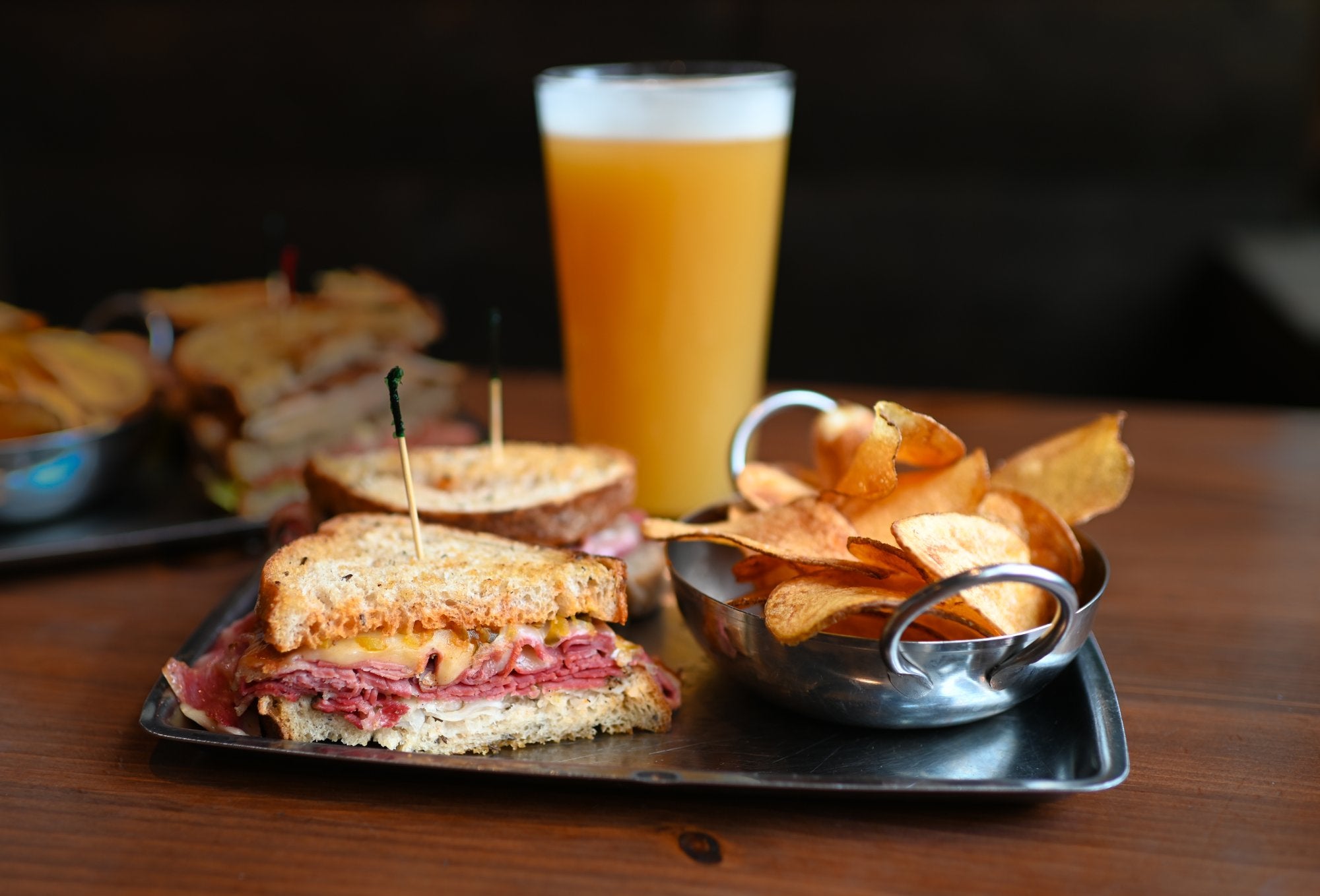 Pastrami and Swiss at A&B Kitchen Bar with a beer in the background