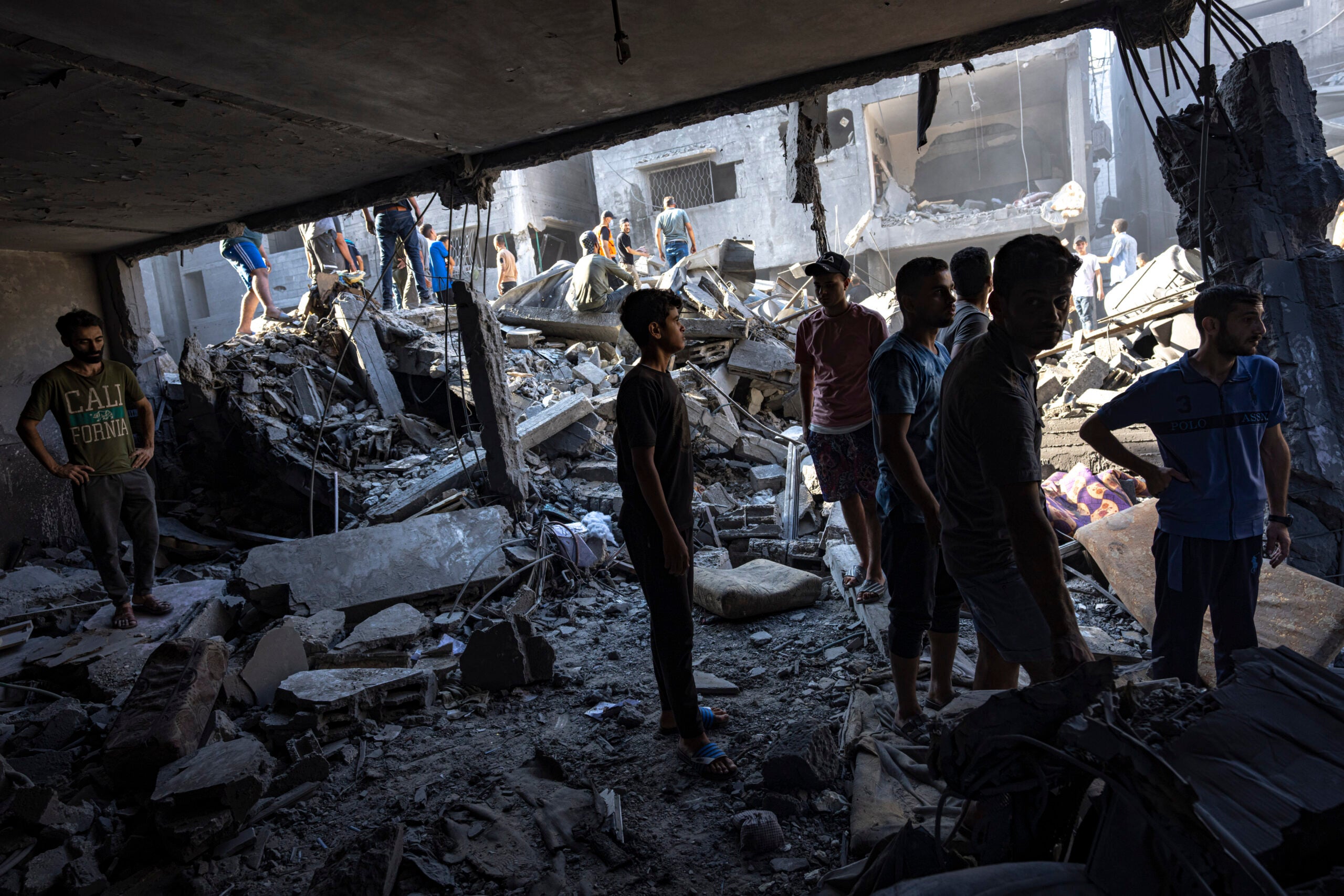 Palestinians search for bodies and survivors in the rubble of a residential building leveled in an Israeli airstrike, Al Shati Refugee Camp.