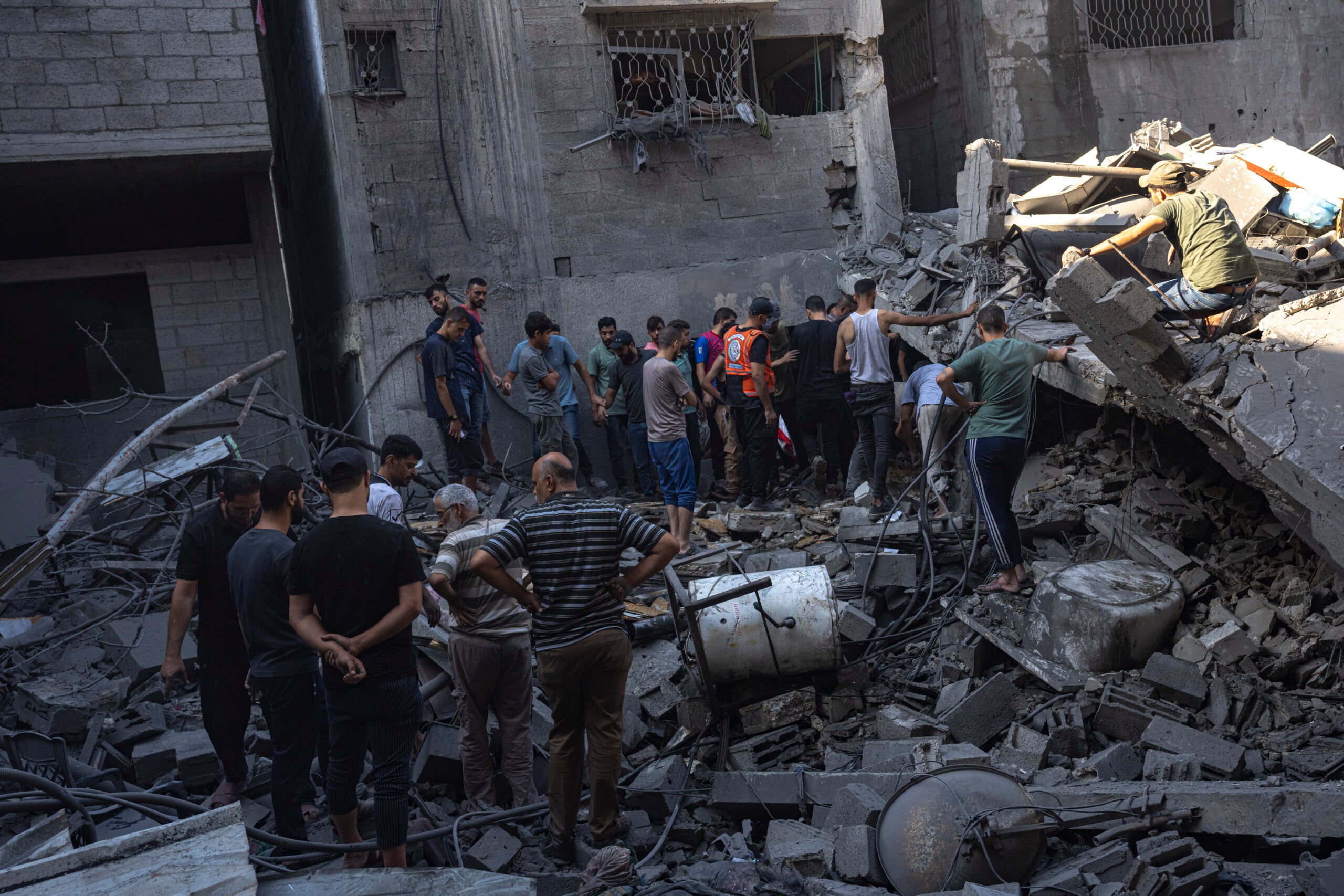 Palestinians search for bodies and survivors in the rubble of a residential building leveled in an Israeli airstrike, Al Shati Refugee Camp. 