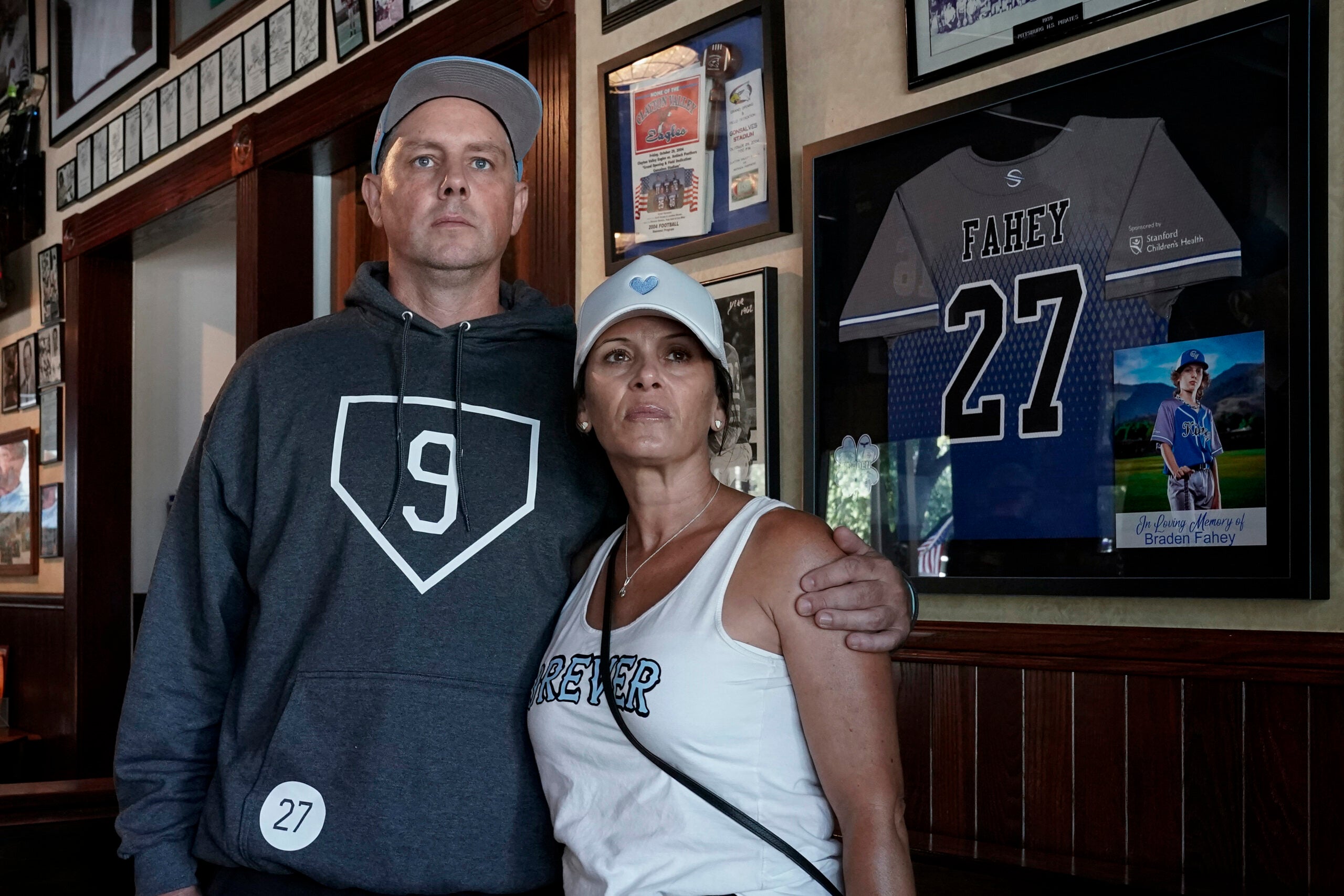 Padrig and Gina Fahey stand for a portrait next to a tribute to their son.