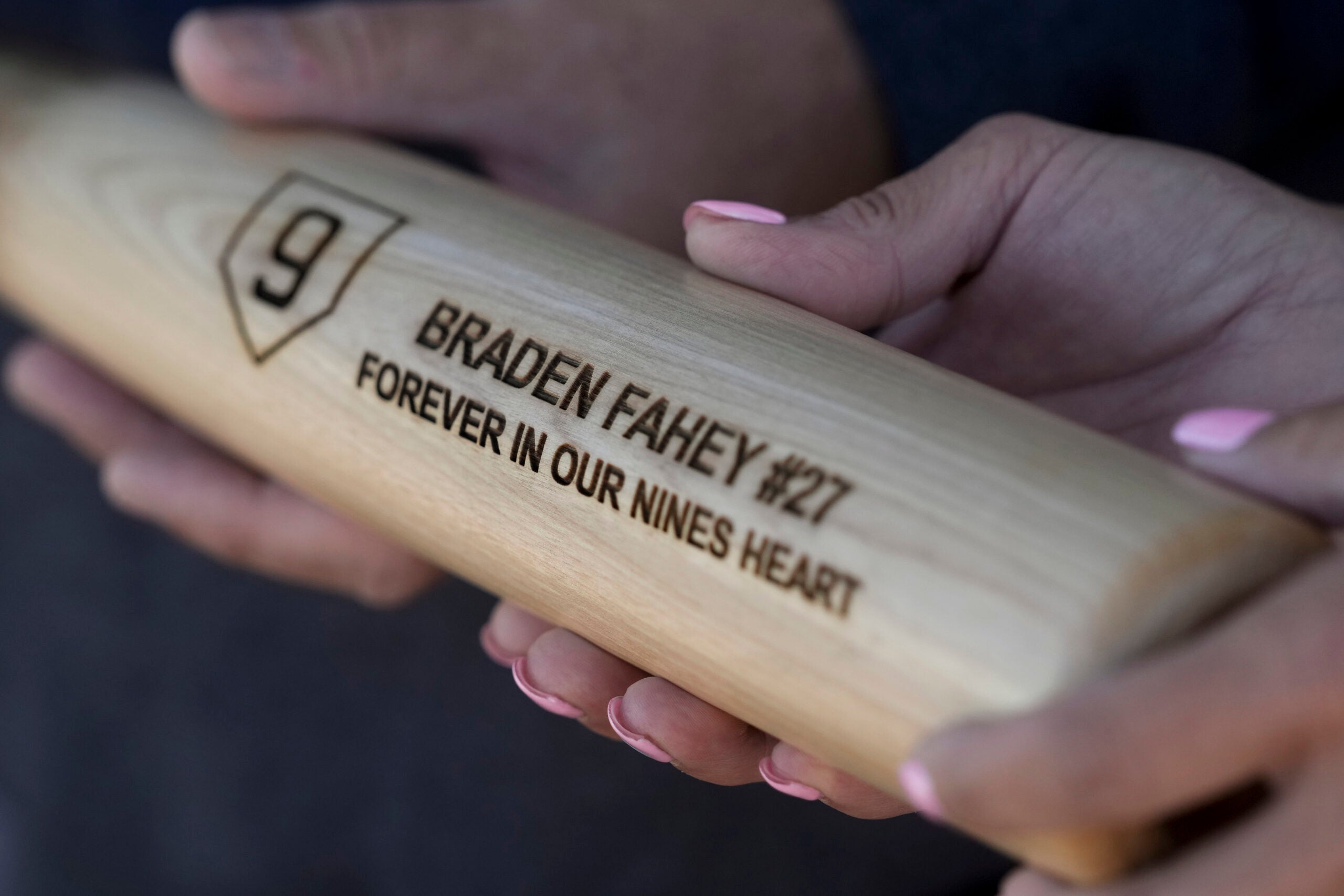 Padrig and Gina Fahey hold a bat dedicated to their son, Braden. 