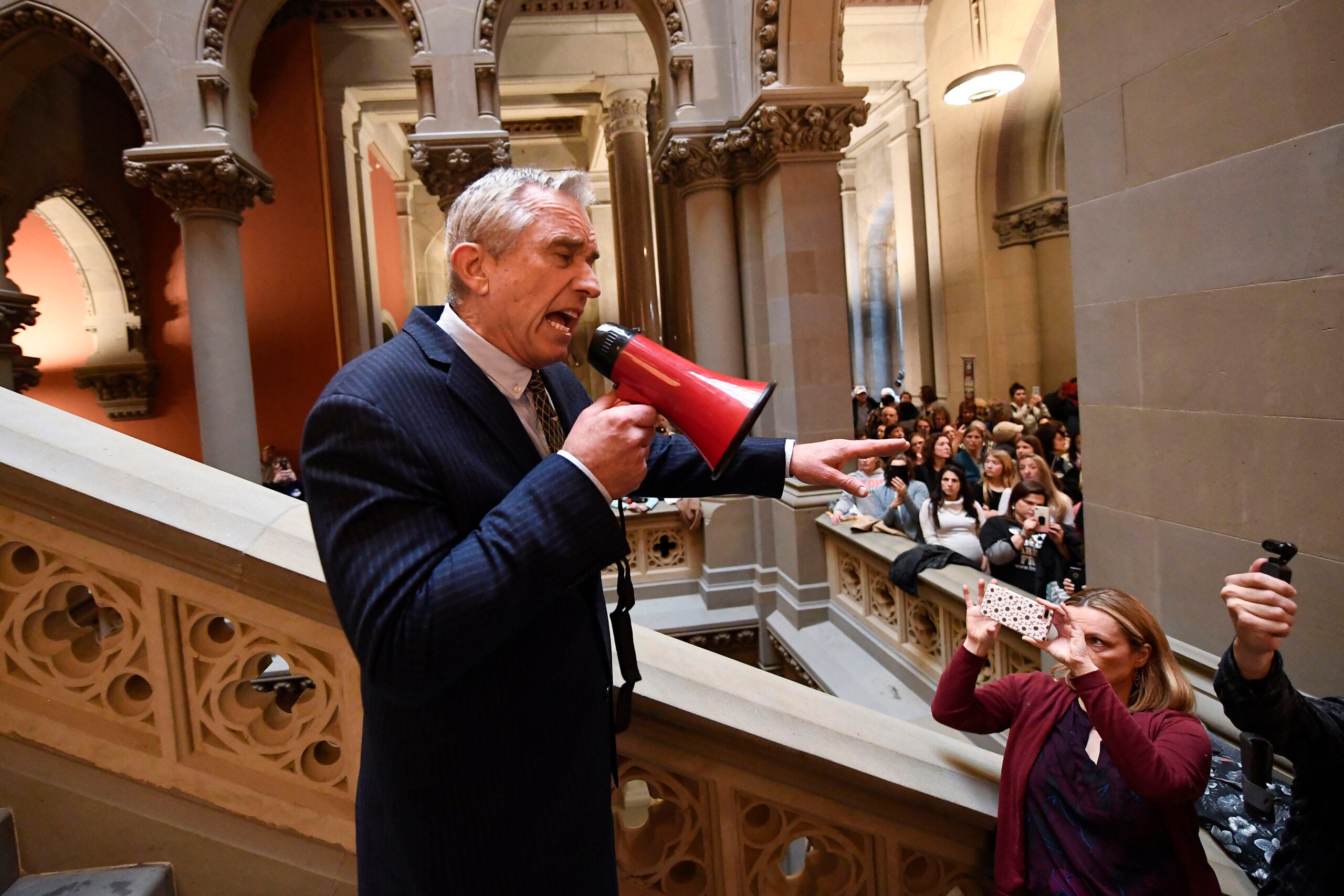 Robert F. Kennedy, Jr., speaks into a red megaphone. 