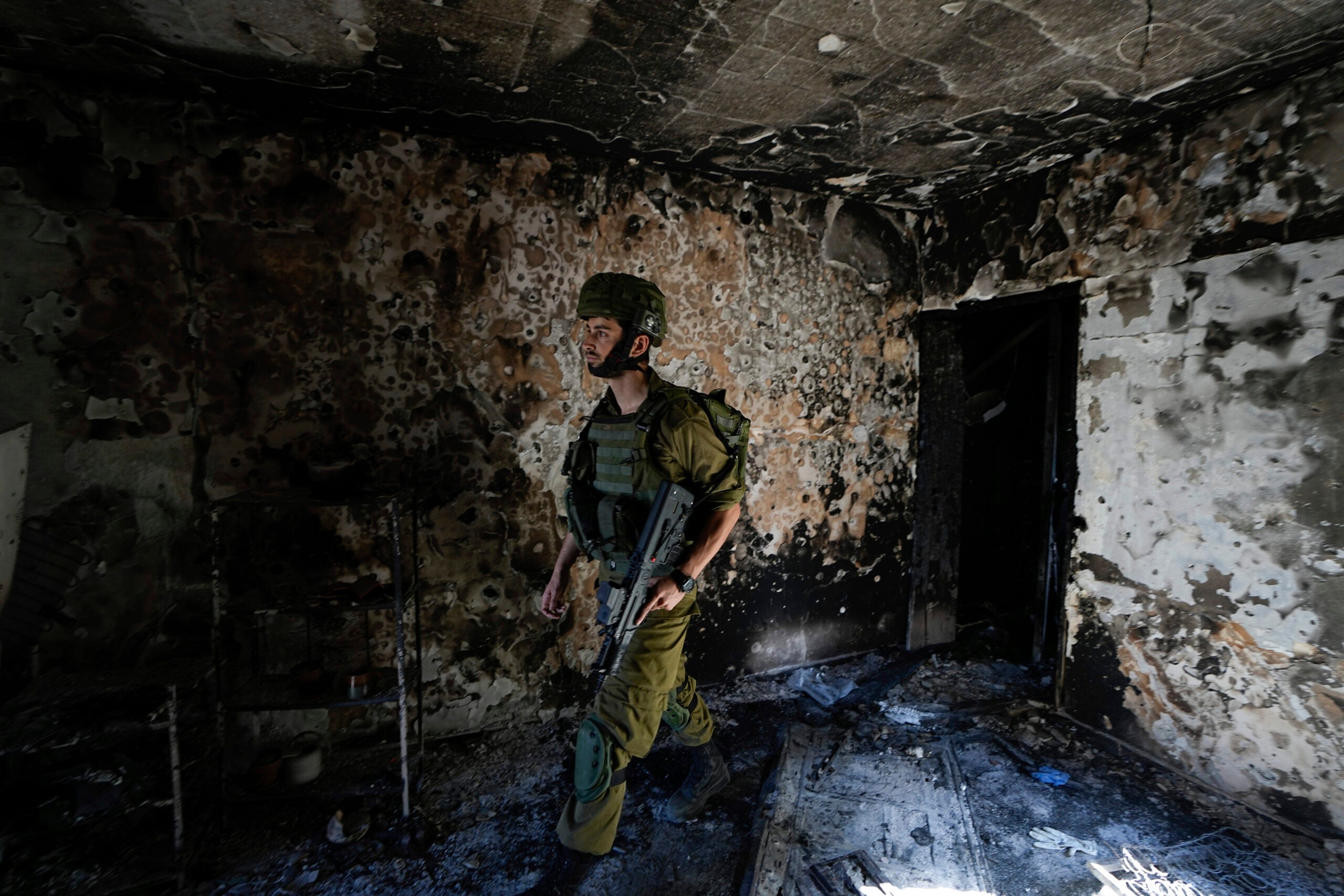 An Israeli soldier inspects a house damaged. 