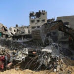 Palestinians inspect the damage of destroyed houses after Israeli airstrikes on Gaza City,.