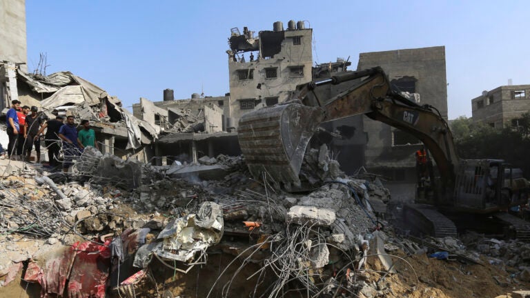 Palestinians inspect the damage of destroyed houses after Israeli airstrikes on Gaza City,.