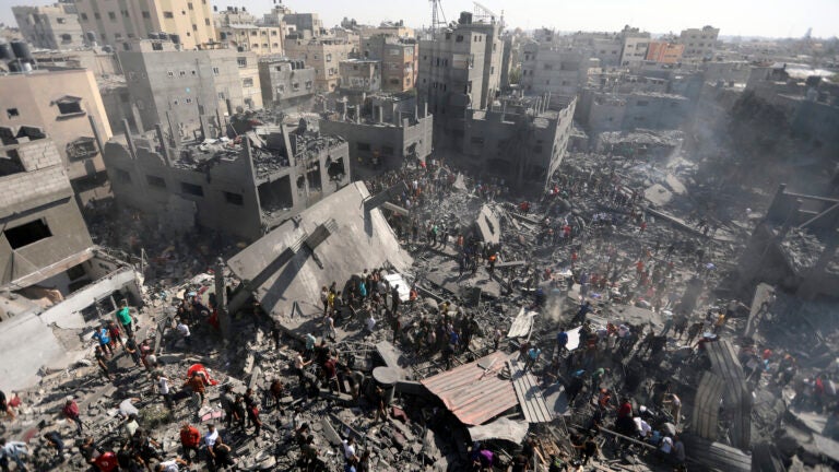 Palestinians inspect the rubble of destroyed buildings following Israeli airstrikes on town of Khan Younis.