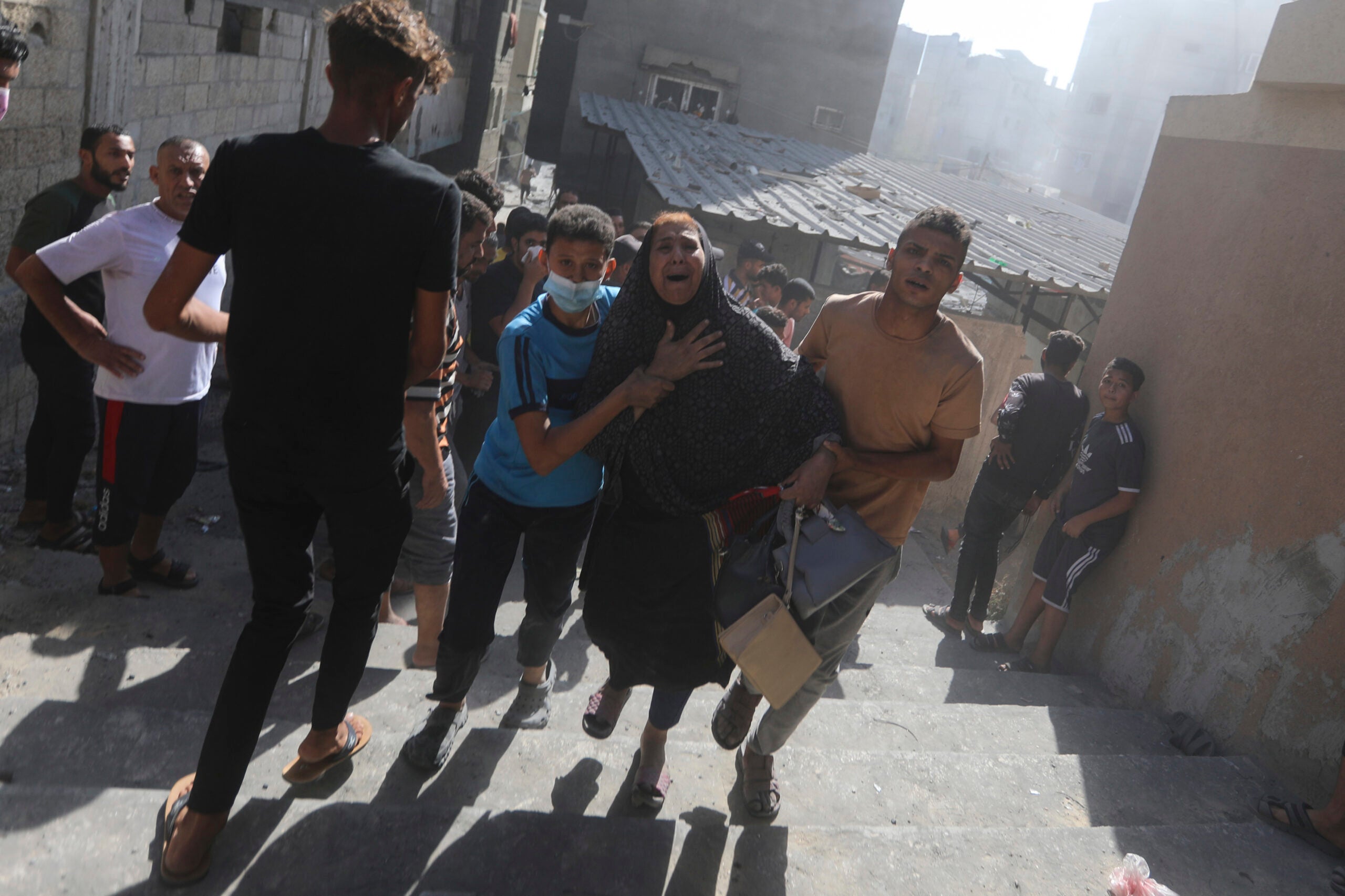 Palestinians evacuate a woman following Israeli airstrikes on town of Khan Younis. 