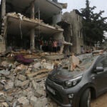 Palestinians stand around a building destroyed in the Israeli bombardment of the Gaza Strip.