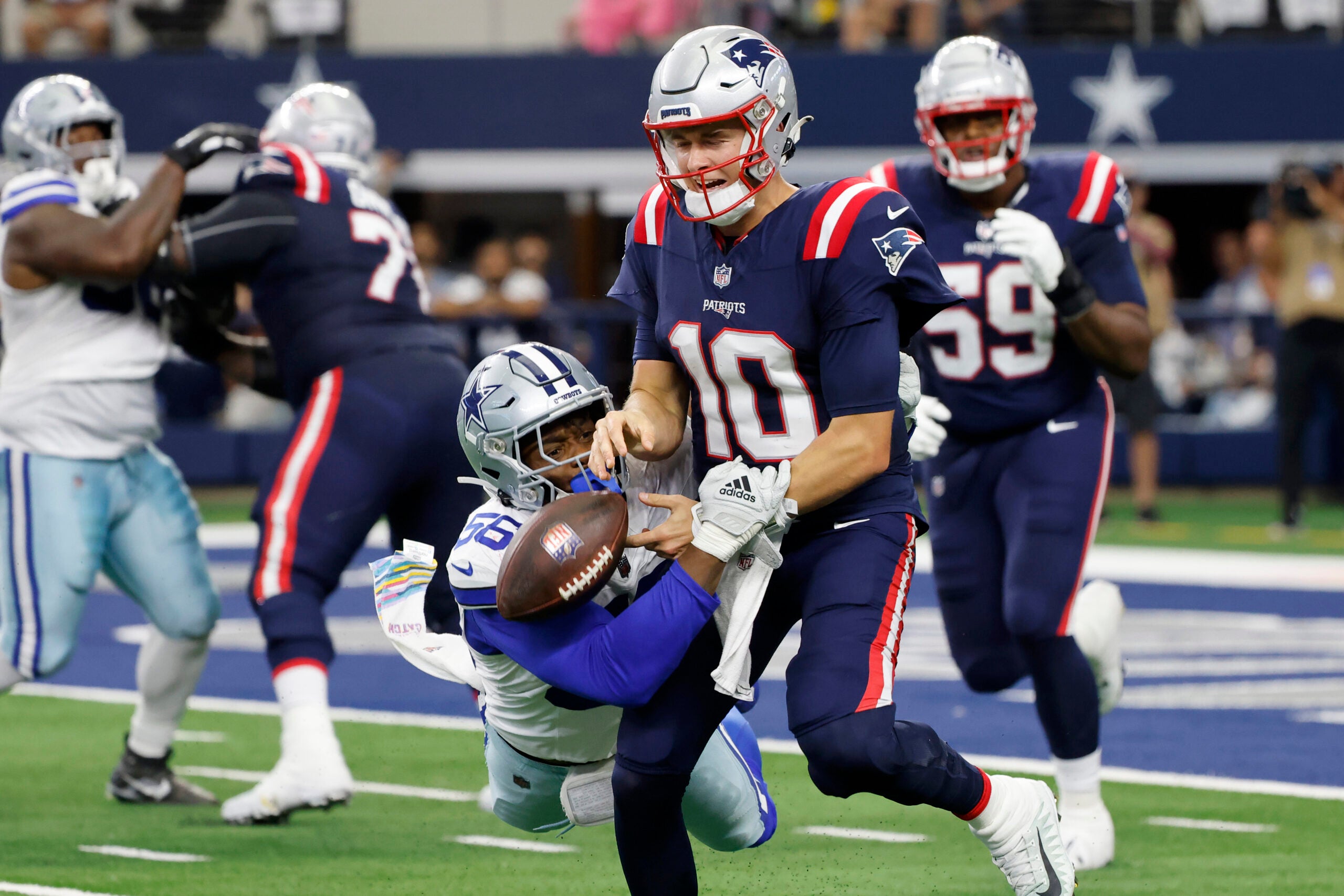 Dallas Cowboys defensive end Dante Fowler Jr. strips the ball away from New England Patriots quarterback Mac Jones.