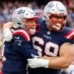 New England Patriots guard Cole Strange (69) hugs quarterback Mac Jones (10) after scoring the go ahead touchdown during the second half of an NFL football game against the Buffalo Bills on Sunday, Oct. 22, 2023, in Foxborough, Mass.