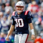 New England Patriots quarterback Mac Jones smiles while leading during the first half of an NFL football game against the Buffalo Bills, Sunday, Oct. 22, 2023, in Foxborough, Mass.