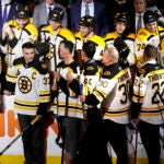 Boston Bruins alumni stand in front of this season's team during a celebration for the 100th year of the NHL hockey team, prior to the team's home-opener against the Chicago Blackhawks on Wednesday, Oct. 11, 2023, in Boston.