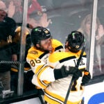 Boston Bruins right wing David Pastrnak (88) is embraced by Milan Lucic after his goal against the Chicago Blackhawks during the second period of an NHL hockey game Wednesday, Oct. 11, 2023, in Boston.