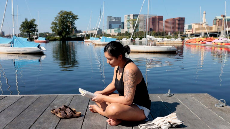Boston weather Katelyn Alvarez, a nurse at MGH who was able to get out of work early decided to stop along the Charles River Esplanade to read a book and enjoy the weather as temperatures were expected to climb into the 80’s. (Jessica Rinaldi/Globe Staff)