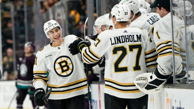 Boston Bruins center Matthew Poitras, left, celebrates his goal with the bench during the third period of an NHL hockey game against the Anaheim Ducks Sunday, Oct. 22, 2023, in Anaheim, Calif.