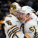 Boston Bruins center Matthew Poitras, right, celebrates with goaltender Linus Ullmark after the team's win against the Anaheim Ducks in an NHL hockey game Sunday, Oct. 22, 2023, in Anaheim, Calif.