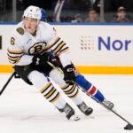 Boston Bruins' Mason Lohrei looks to pass the puck away from New York Rangers' Kaapo Kakko during the second period of an NHL preseason hockey game Thursday, Oct. 5, 2023, in New York.