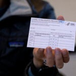FILE - A nurse practitioner holds a COVID-19 vaccine card at a New York Health and Hospitals vaccine clinic in the Brooklyn borough of New York on Jan. 10, 2021.