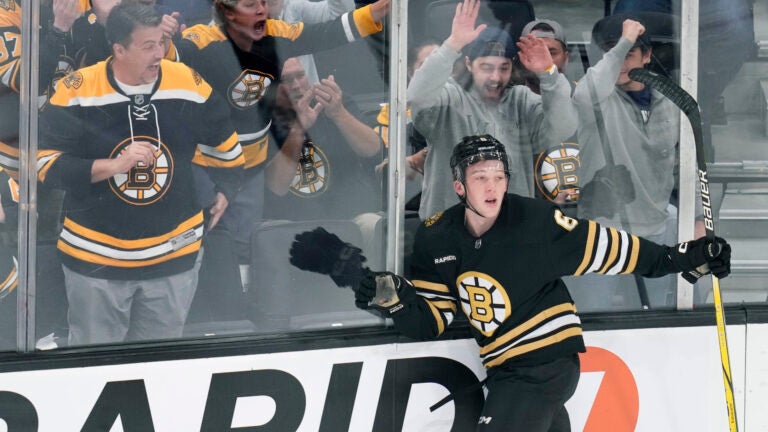 Boston Bruins defenseman Mason Lohrei and fans celebrate his goal against the Washington Capitals during the first period of a preseason NHL hockey game Tuesday, Oct. 3, 2023, in Boston.