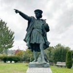 A statue of Christopher Columbus stands in a park.