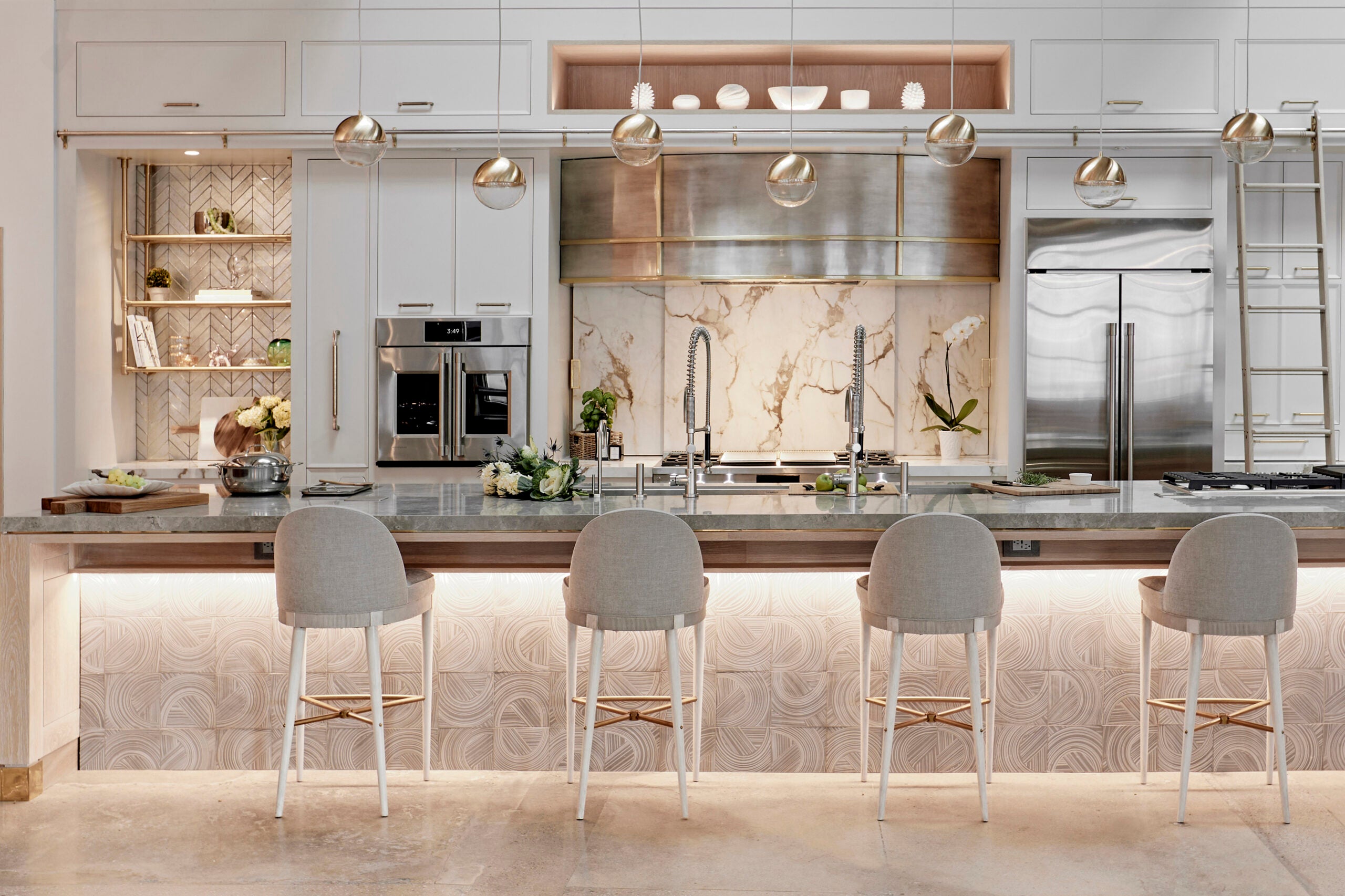 Kitchen with spherical lighting above, and lighting underneath island seating. 