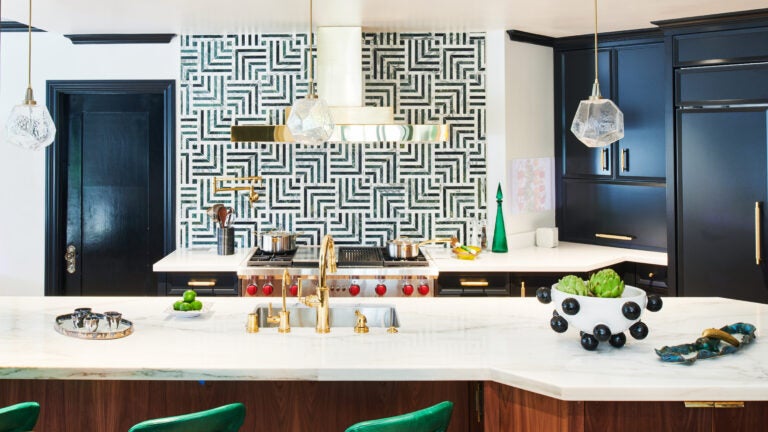 Kitchen with blue-green cabinets, and unique backsplash.