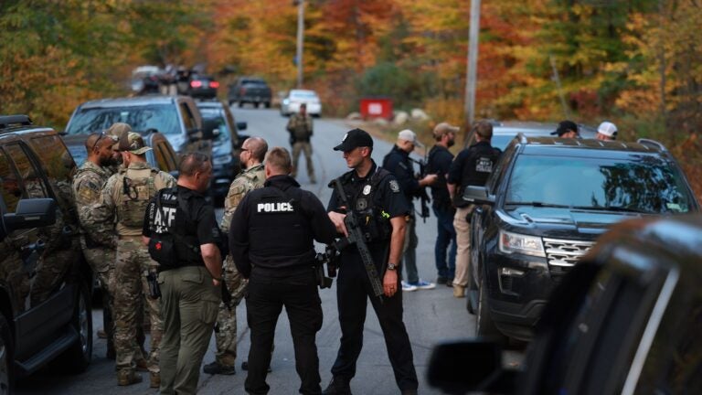 Law enforcement officials gather in the road leading to the home of the suspect being sought in connection with two mass shootings on October 26, 2023 in Bowdoin, Maine. Police are searching for U.S. Army Reservist Robert Card, 40, who is wanted in the shooting deaths of 18 people at a bowling alley and a bar last night in nearby Lewiston. At least 13 others were wounded in the rampage.