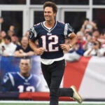 Former New England Patriots quarterback Tom Brady runs on the field during halftime ceremonies held to honor him.