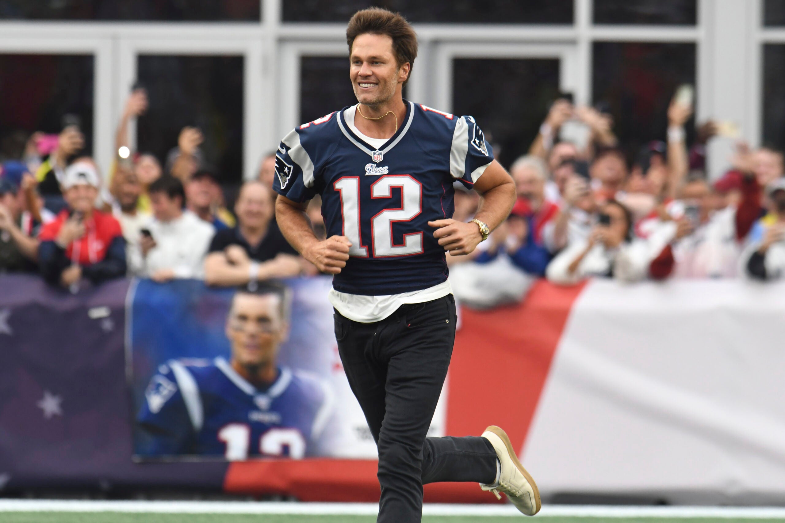 Former New England Patriots quarterback Tom Brady runs on the field during halftime ceremonies held to honor him.