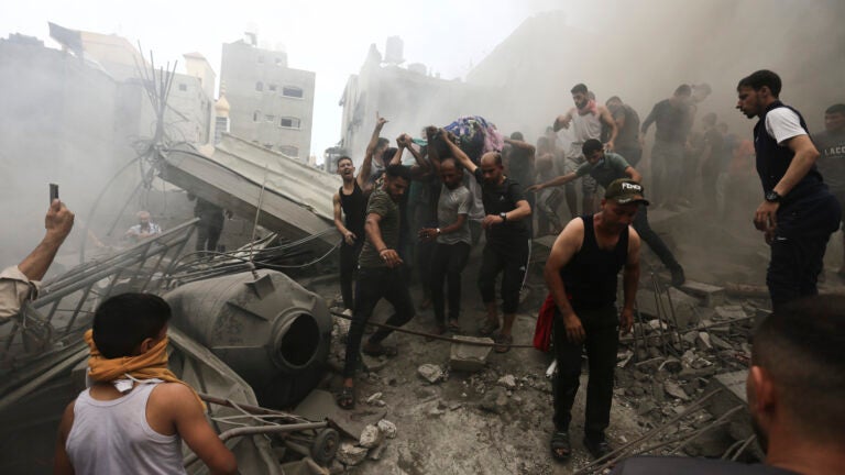 Palestinians remove a dead body from the rubble of a building after an Israeli airstrike Jebaliya refugee camp, Gaza Strip, Monday, Oct. 9, 2023.