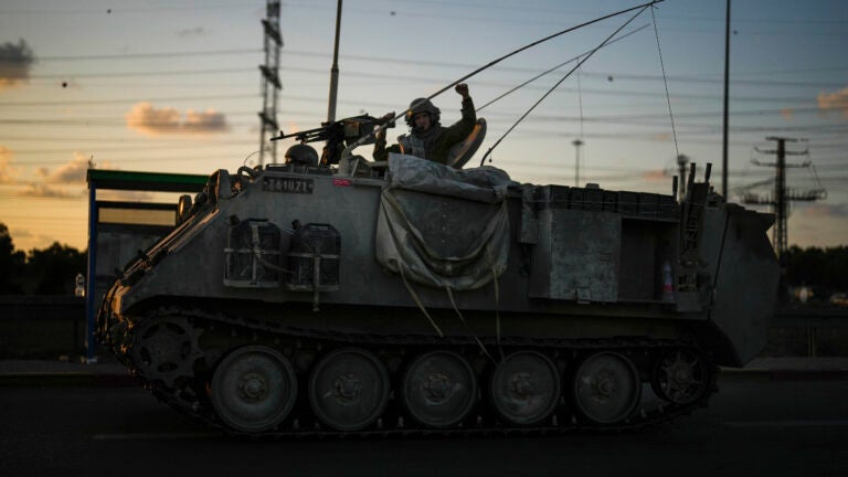 An Israel soldier gestures to passers-by as he drives a military vehicle near the border between Israel and Gaza Strip.