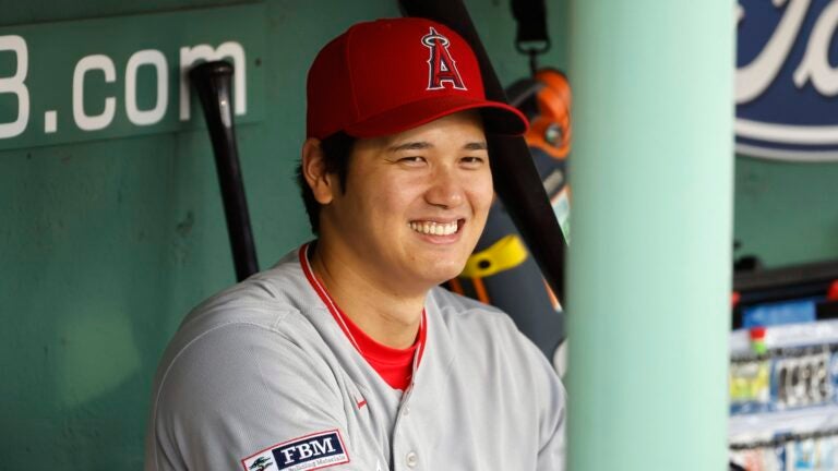 Shohei Ohtani #17 of the Los Angeles Angels smiles in the dugout before their game against the Boston Red Sox at Fenway Park on April 16, 2023 in Boston, Massachusetts.