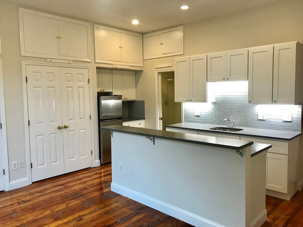 Kitchen with white cabinets in Boston apartment. 