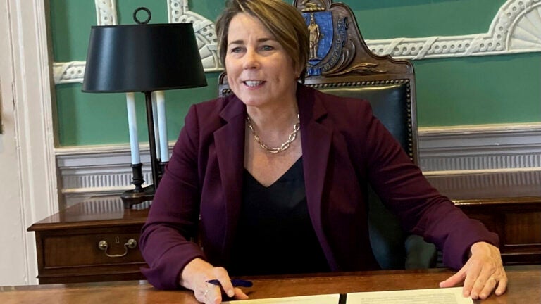 Massachusetts Democratic Gov. Maura Healey talks while seated at a desk.