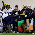 Michigan State quarterback Sam Leavitt is hit out of bounds by Michigan defensive back DJ Waller Jr.