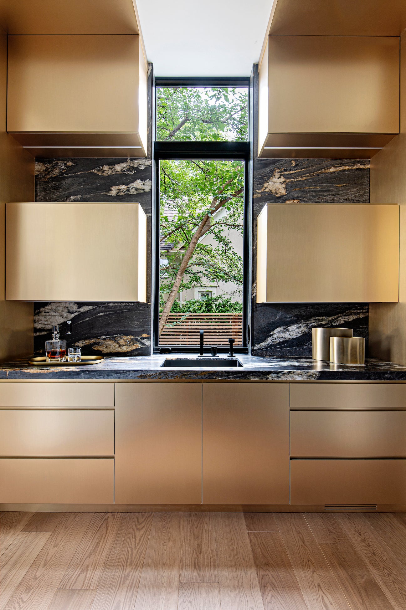 Kitchen with two upper cabinets, and lower drawers with gold accents.