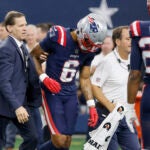 New England Patriots cornerback Christian Gonzalez (6) is escorted off the field after an injury during an NFL Football game against the Dallas Cowboys in Arlington, Texas, Sunday, Nov. 1, 2023.
