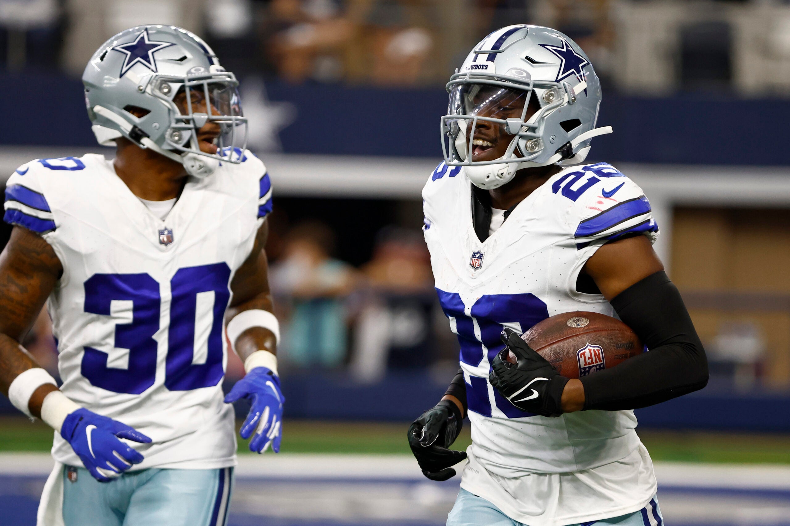 Dallas Cowboys cornerback DaRon Bland and safety Juanyeh Thomas celebrate on the field. 