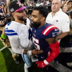 Dallas Cowboys quarterback Dak Prescott (4) and New England Patriots running back Ezekiel Elliott (15) greet each other after an NFL football game, Sunday, Oct. 1, 2023, in Arlington, Texas. Dallas won 38-3