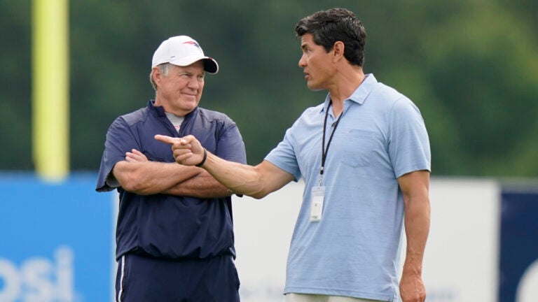 New England Patriots head coach Bill Belichick, left, smiles while speaking with former Patriots player Tedy Bruschi, right, during an NFL football practice, Tuesday, Aug. 3, 2021, in Foxborough, Mass.