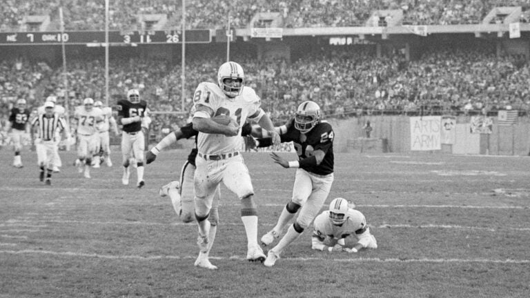 FILE - New England Patriots' Russ Francis carries for a touchdown against the Oakland Raiders during a Dec. 18, 1976 game.