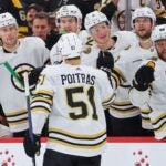 Matthew Poitras #51 of the Boston Bruins fist bumps teammates after scoring a goal against the Chicago Blackhawks during the third period at the United Center on October 24, 2023 in Chicago, Illinois.