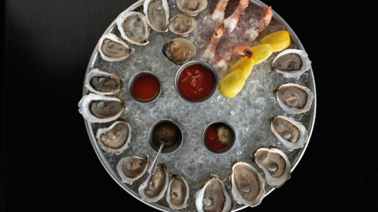 A large platter of ice with oysters and shrimp cocktail at Row 34