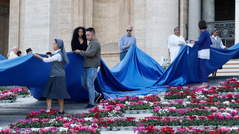 Pope Francis looks at representatives of the synod, refugees, and the vulnerable laying out a symbolic "river."