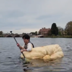 Ben Chang paddles a pumpkin across the Charles.