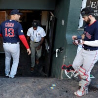 Alex Cora begins walking down the dugout tunnel as catcher Connor Wong follows from the right.