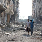 People walk amid debris from Israeli airstrikes in the Jabalia refugee camp in northern Gaza, Oct. 11, 2023.