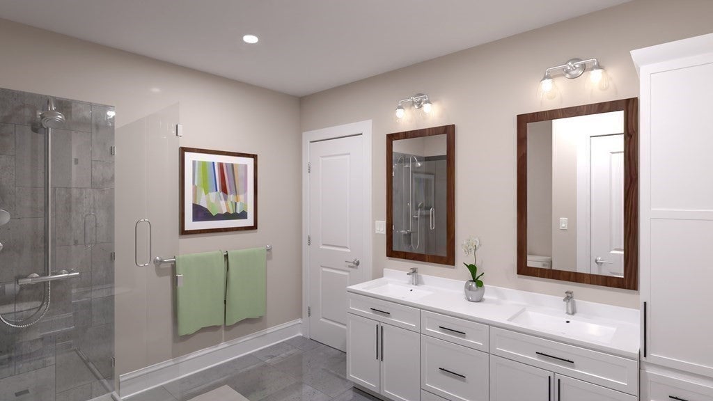 Bathroom with two sinks, white cabinets, and glass shower in Quincy rental. 