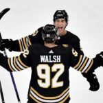 Boston Bruins’ Matthew Poitras and Reilly Walsh celebrate Poitras’ goal during the first period of an NHL exhibition game at TD Garden in Boston, Sunday, Sept. 24, 2023