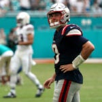 New England Patriots quarterback Mac Jones (10) looks at the scoreboard replay after the Patriots last play. - The Miami Dolphins host the New England Patriots on October 29, 2023 at Hard Rock Stadium in Miami Gardens, FL.